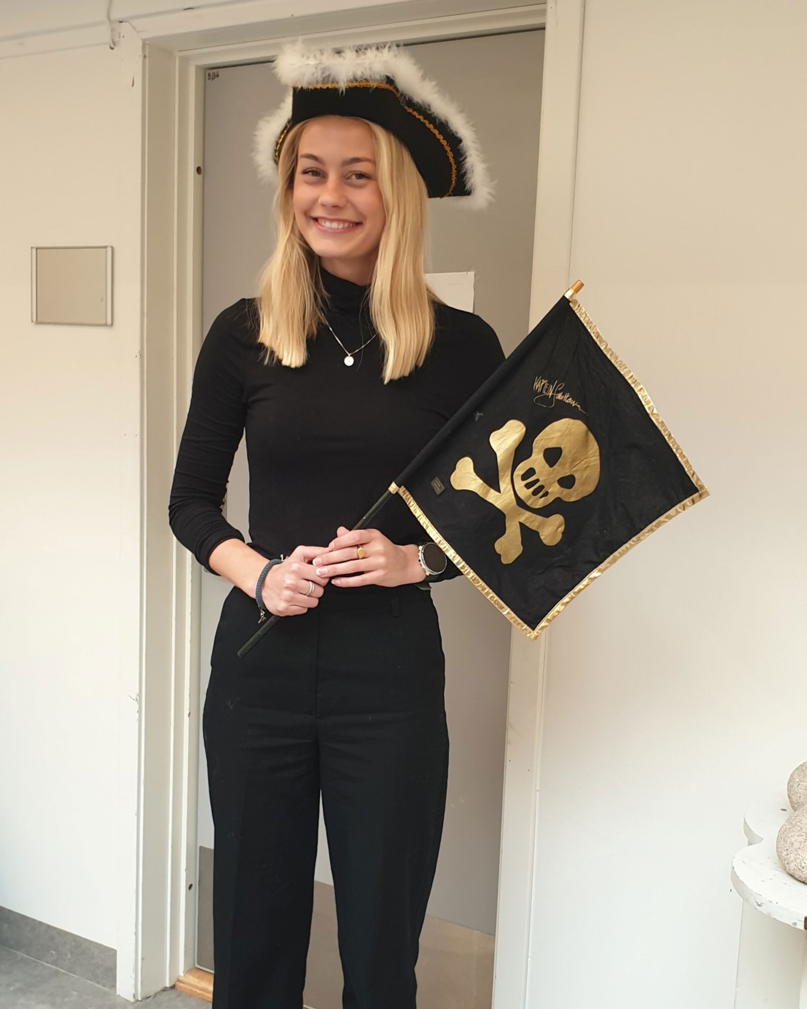 en person iført konfirmasjonslue og kjole