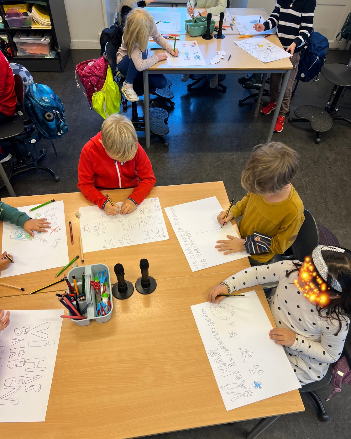 en gruppe mennesker som sitter ved et bord og skriver på papir