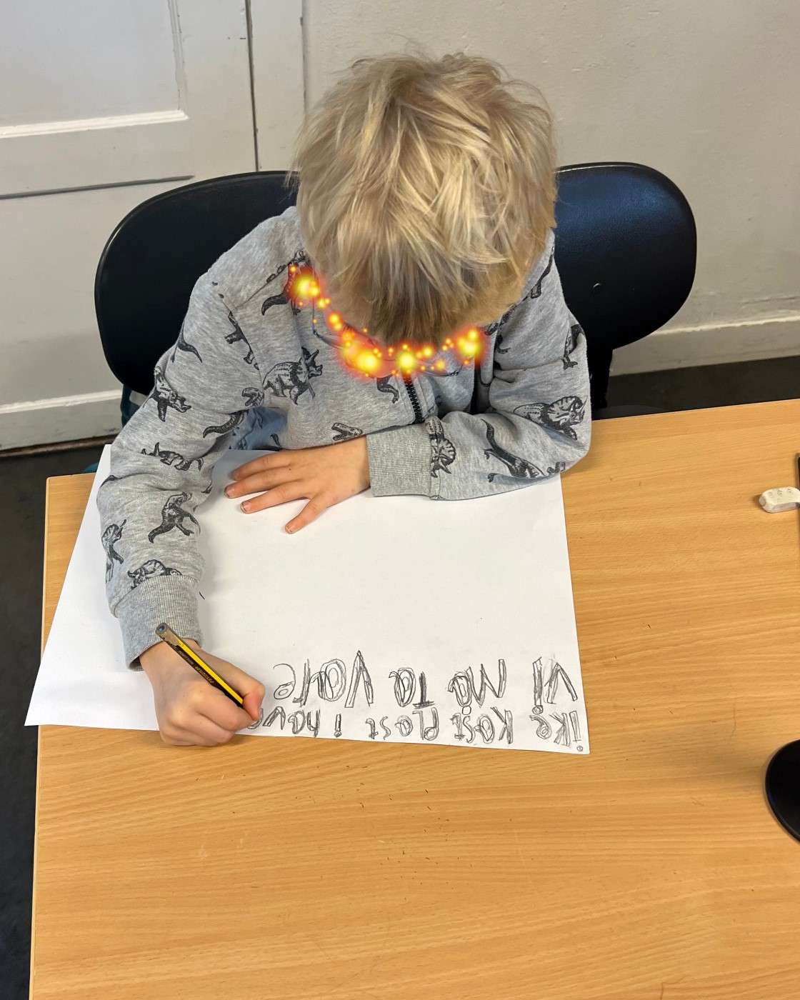 en person som sitter ved et bord og skriver på et stykke papir